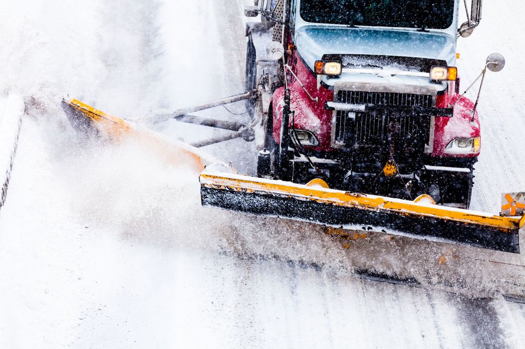 Snowplow Truck Removing the Snow from the Highway during a Snowstorm